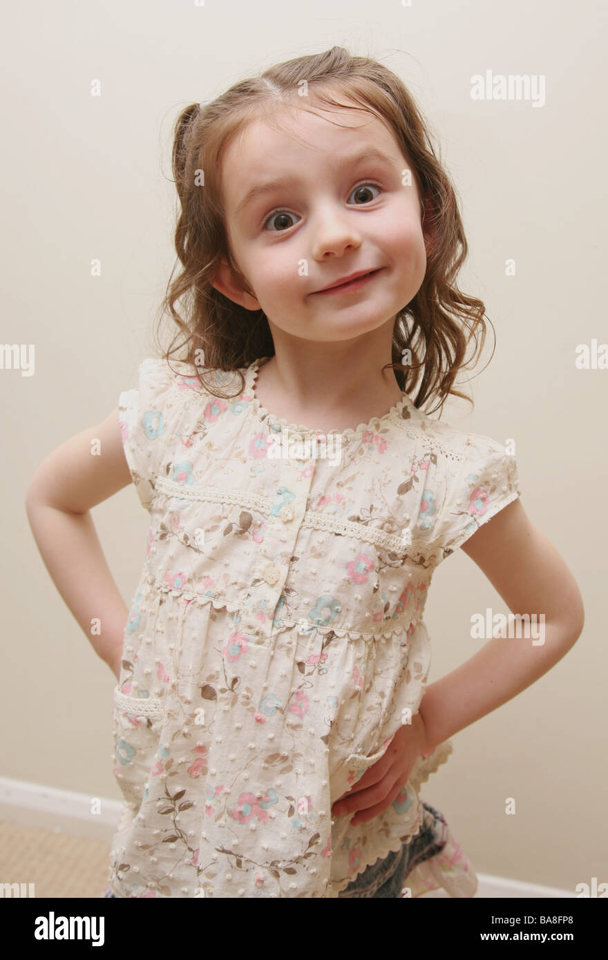 4 year old defiant child standing with her hands on her hips Stock