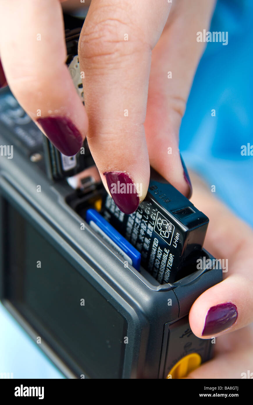 Girl compact digital camera showing battery and memory chip card
