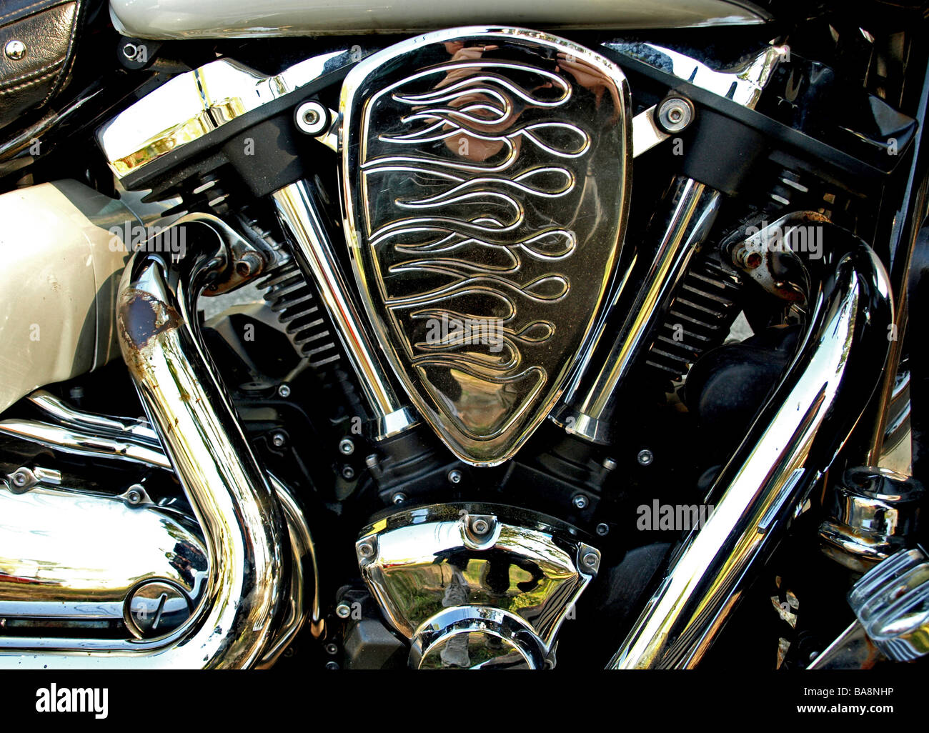 detailed closeup of motorcycle engine pipes and side body with chrome and reflections in silver Stock Photo