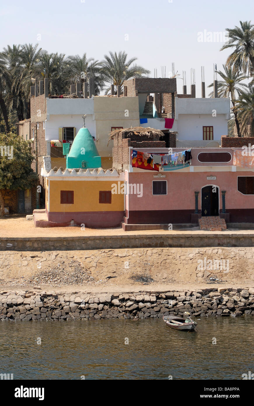 A village with colorful houses at the bank of the River Nile south of ...