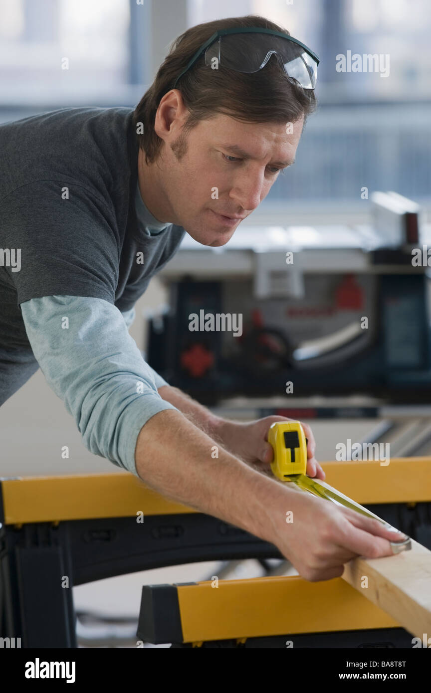 Construction worker measuring board Stock Photo