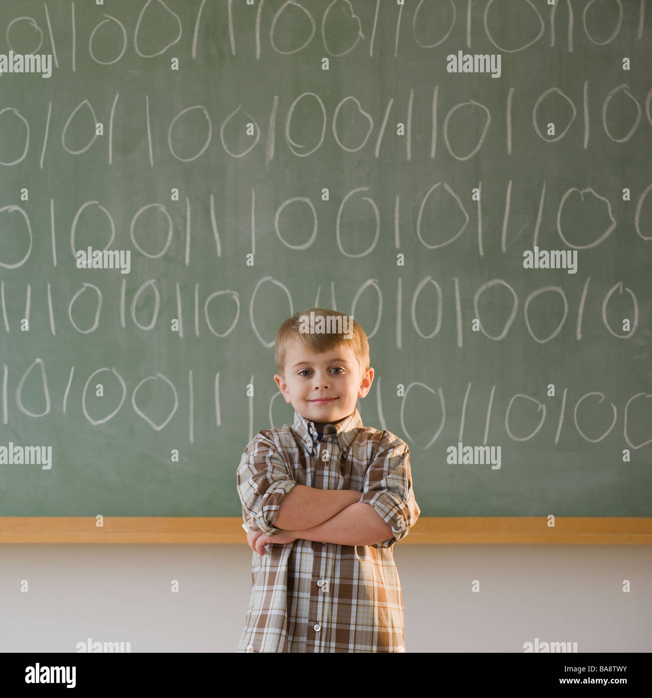 Boy writing binary code on blackboard stock photo alamy