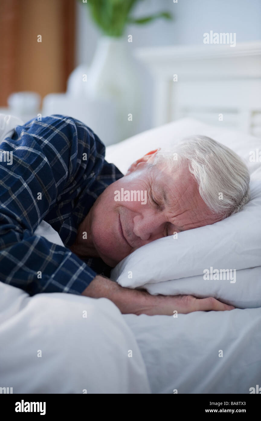 Senior man sleeping in bed Stock Photo