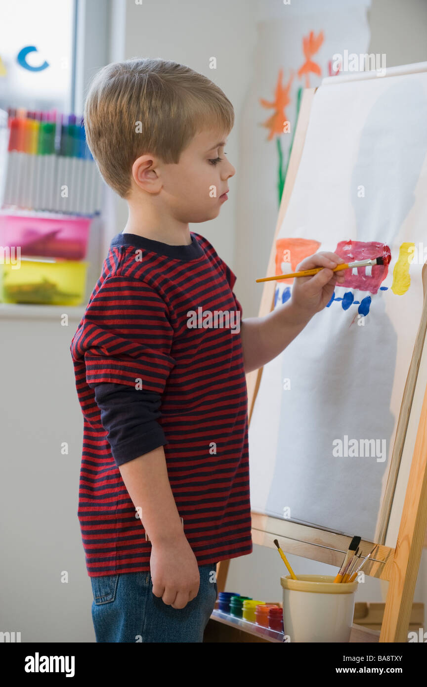 Boy painting on easel Stock Photo Alamy