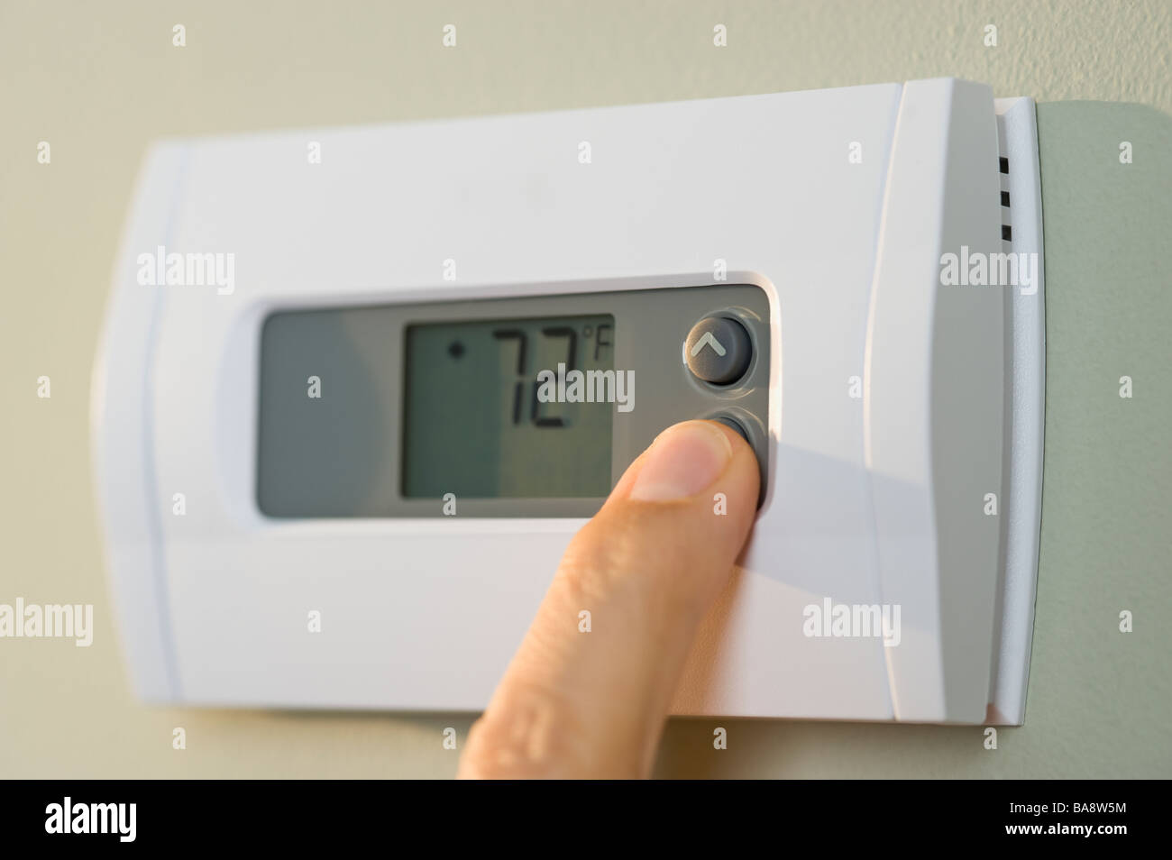 Man adjusting thermostat Stock Photo Alamy