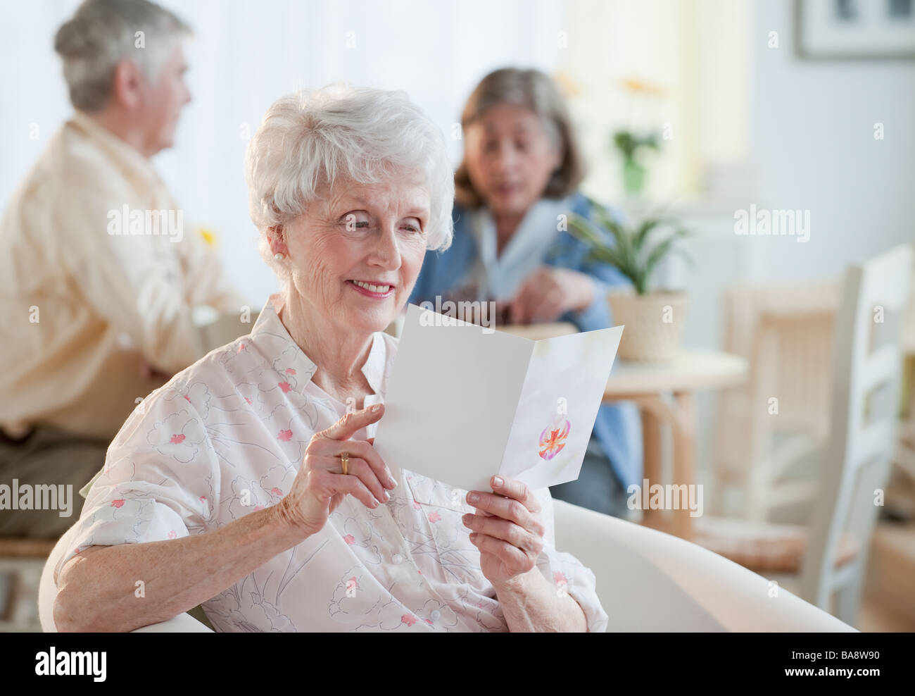 Senior woman reading greeting card Stock Photo