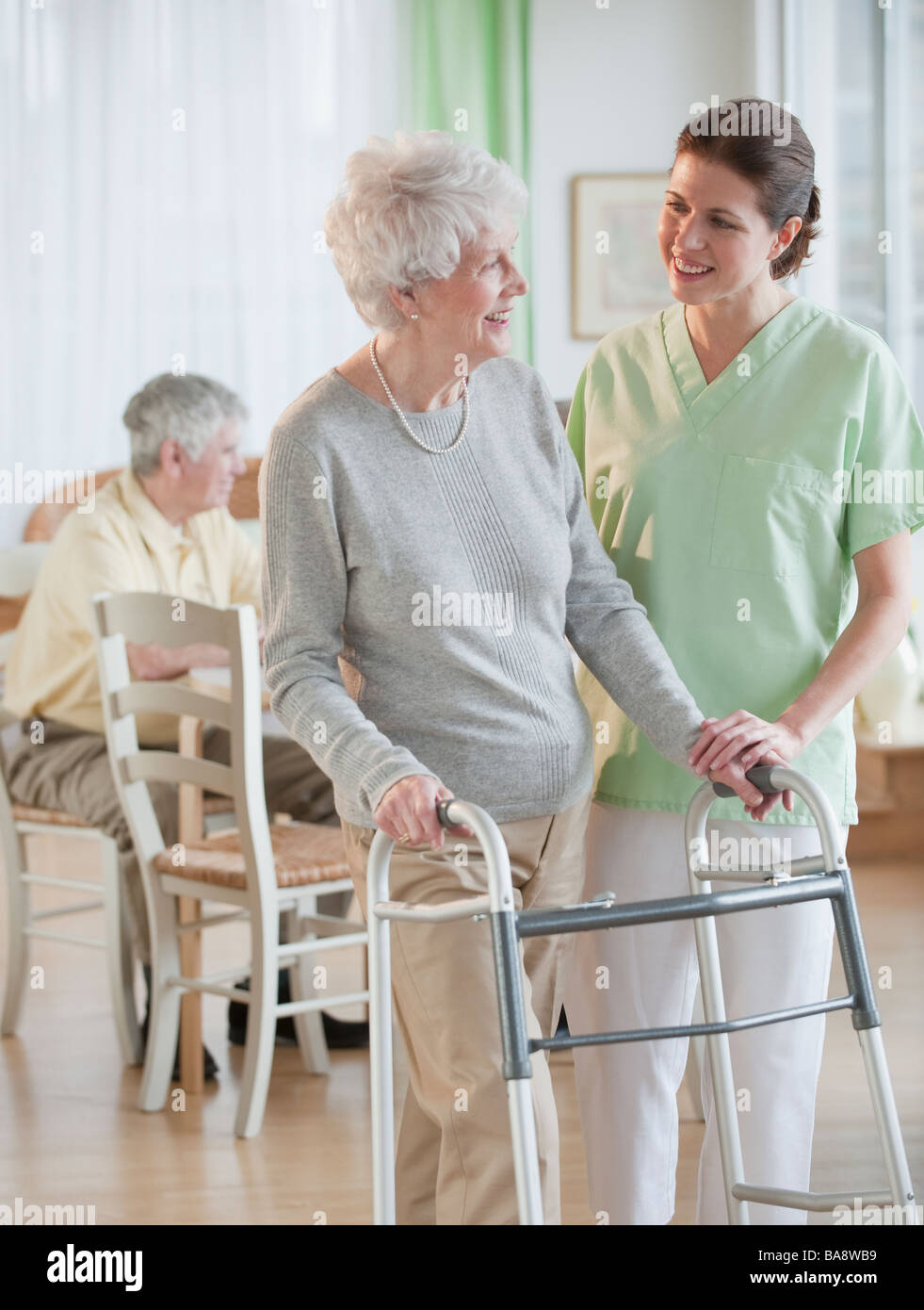 Nurse helping senior woman in walker Stock Photo