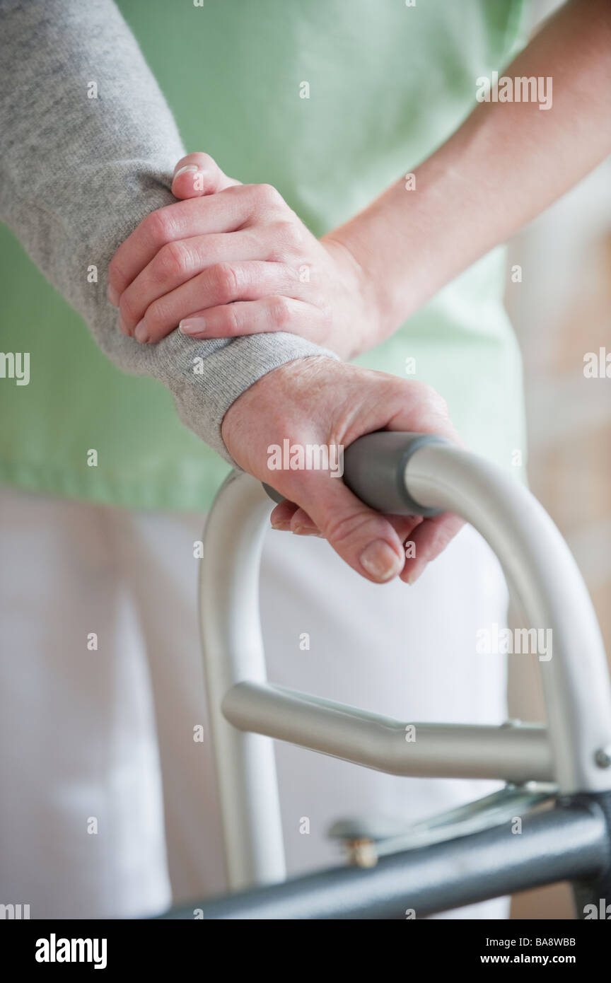 Nurse helping senior woman in walker Stock Photo