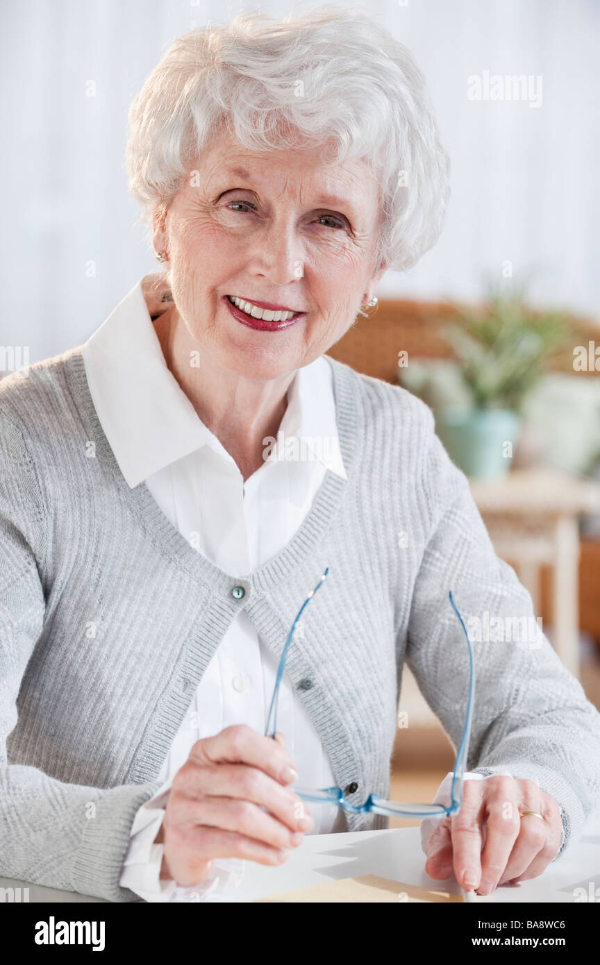 Senior woman sitting at table hi-res stock photography and images - Alamy