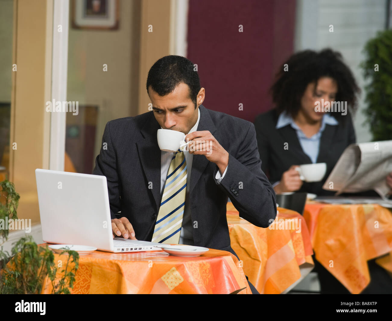 Businessman looking at laptop at outdoor cafe Stock Photo