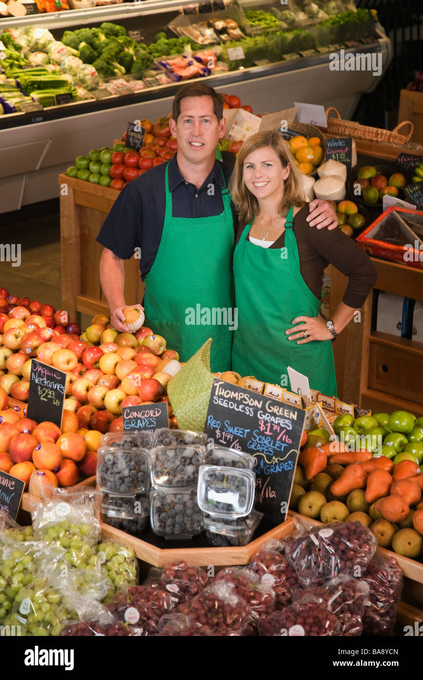 Store owners posing in produce section Stock Photo