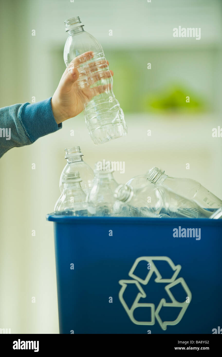 Boy filling recycling bin with water bottles Stock Photo
