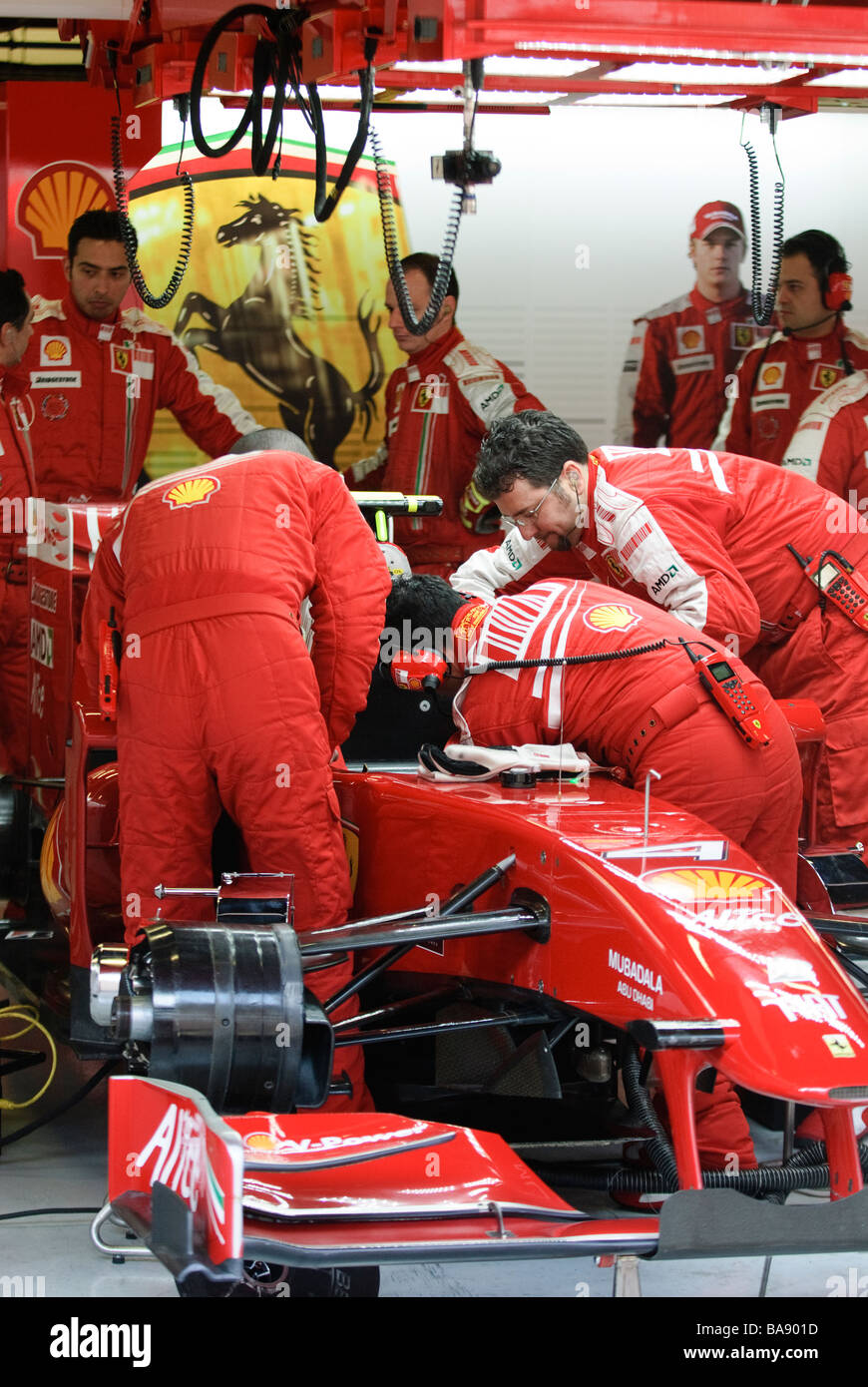 Ferrari Formula One mechanics work on race car in garage Stock Photo