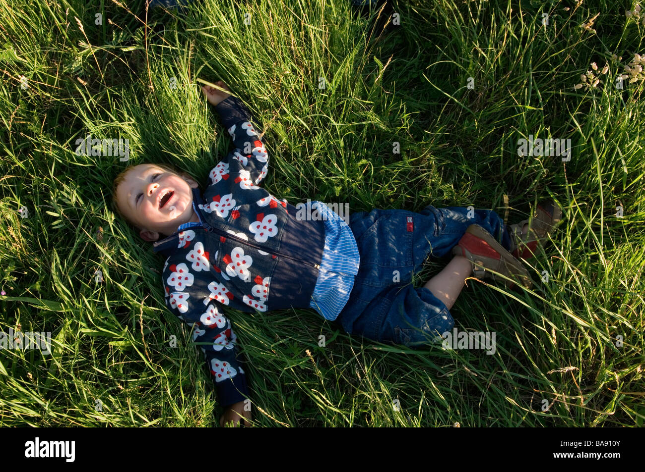 Kids lay in grass hi-res stock photography and images - Alamy