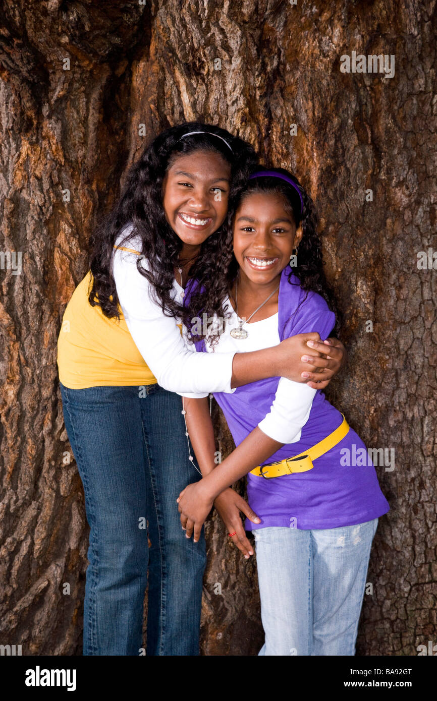 Portrait of African American girls hugging near tree in park Stock Photo