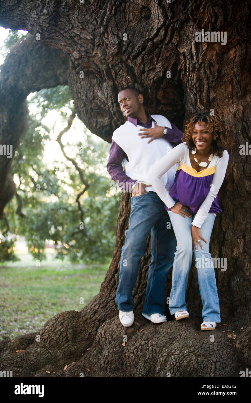 Portrait of African American couple standing near tree in park Stock ...