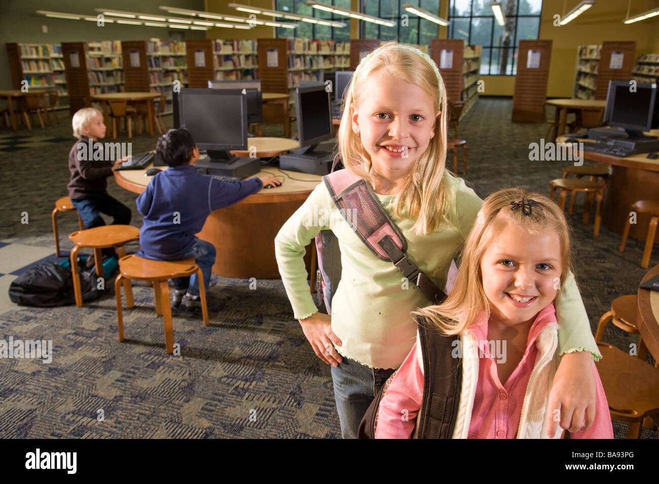 Portrait of two elementary school girls in library Stock Photo - Alamy