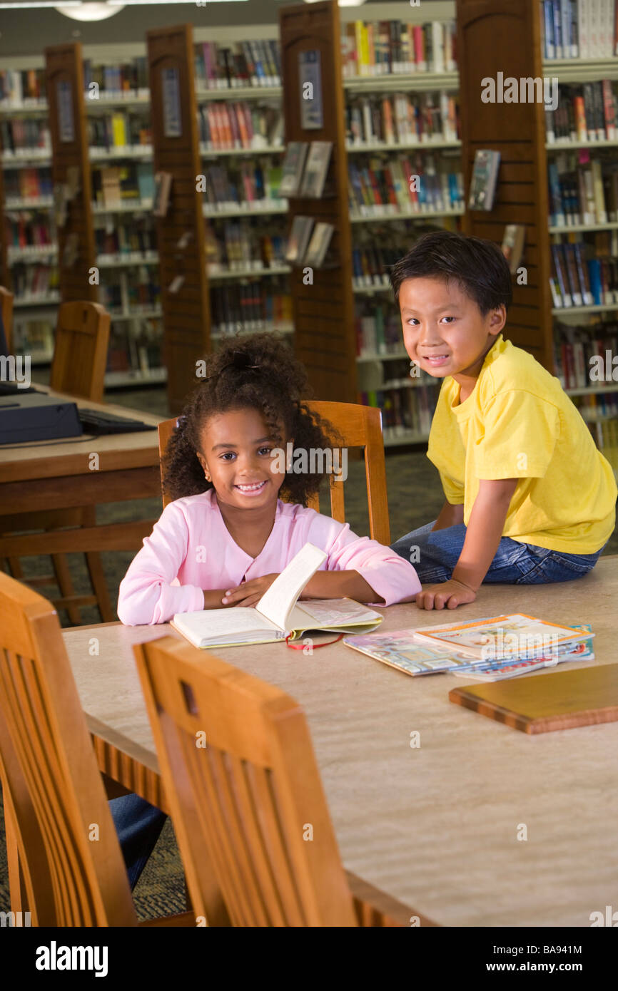 Asian boy and African American girl in library Stock Photo