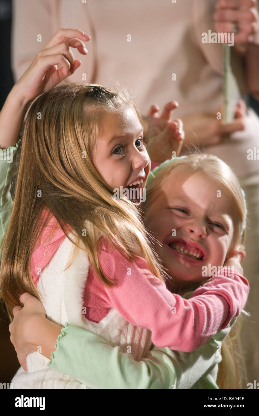 Two elementary school girls hugging and laughing in library Stock Photo ...