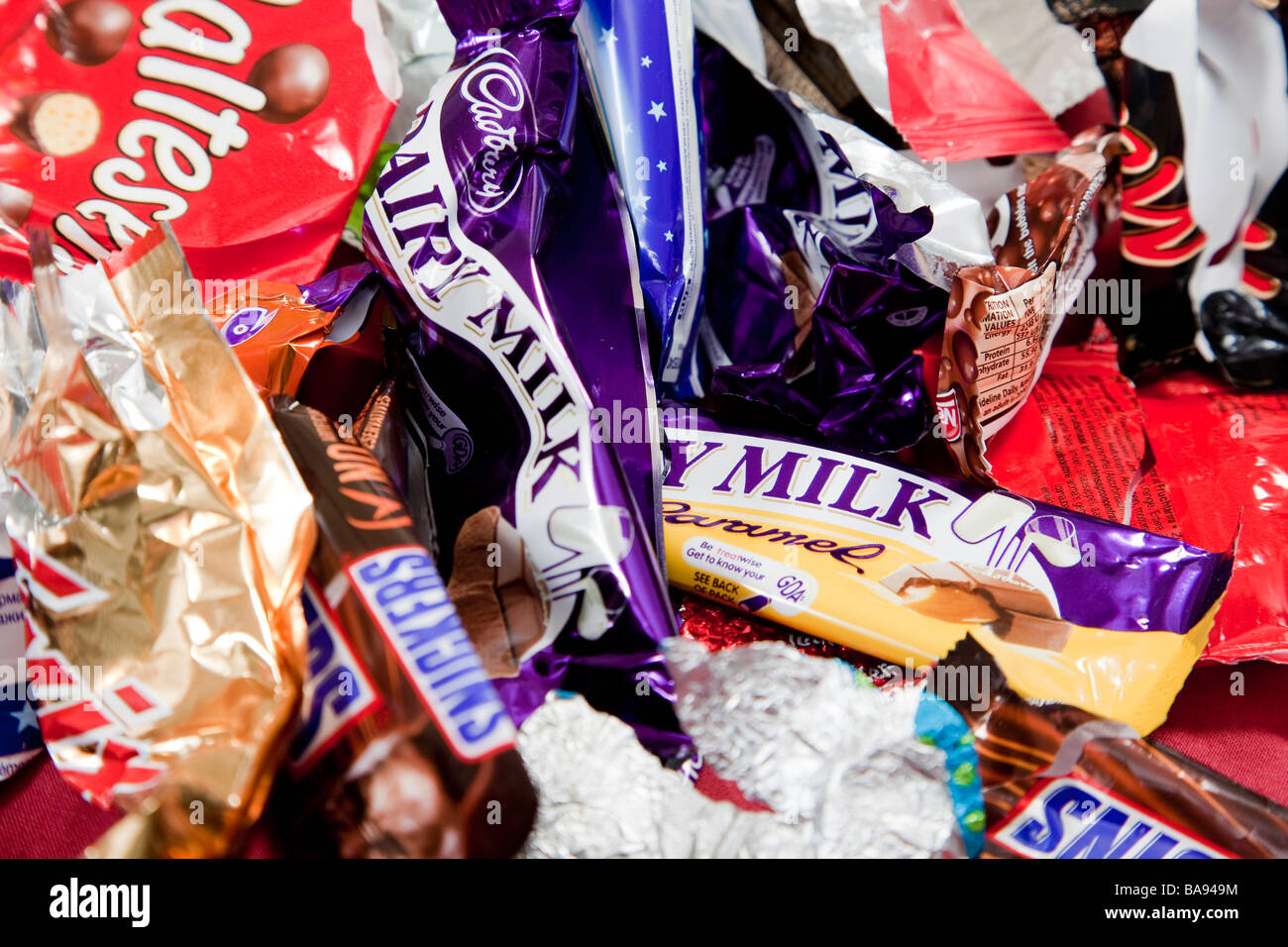 Assorted sweets and chocolate bar wrappers Stock Photo
