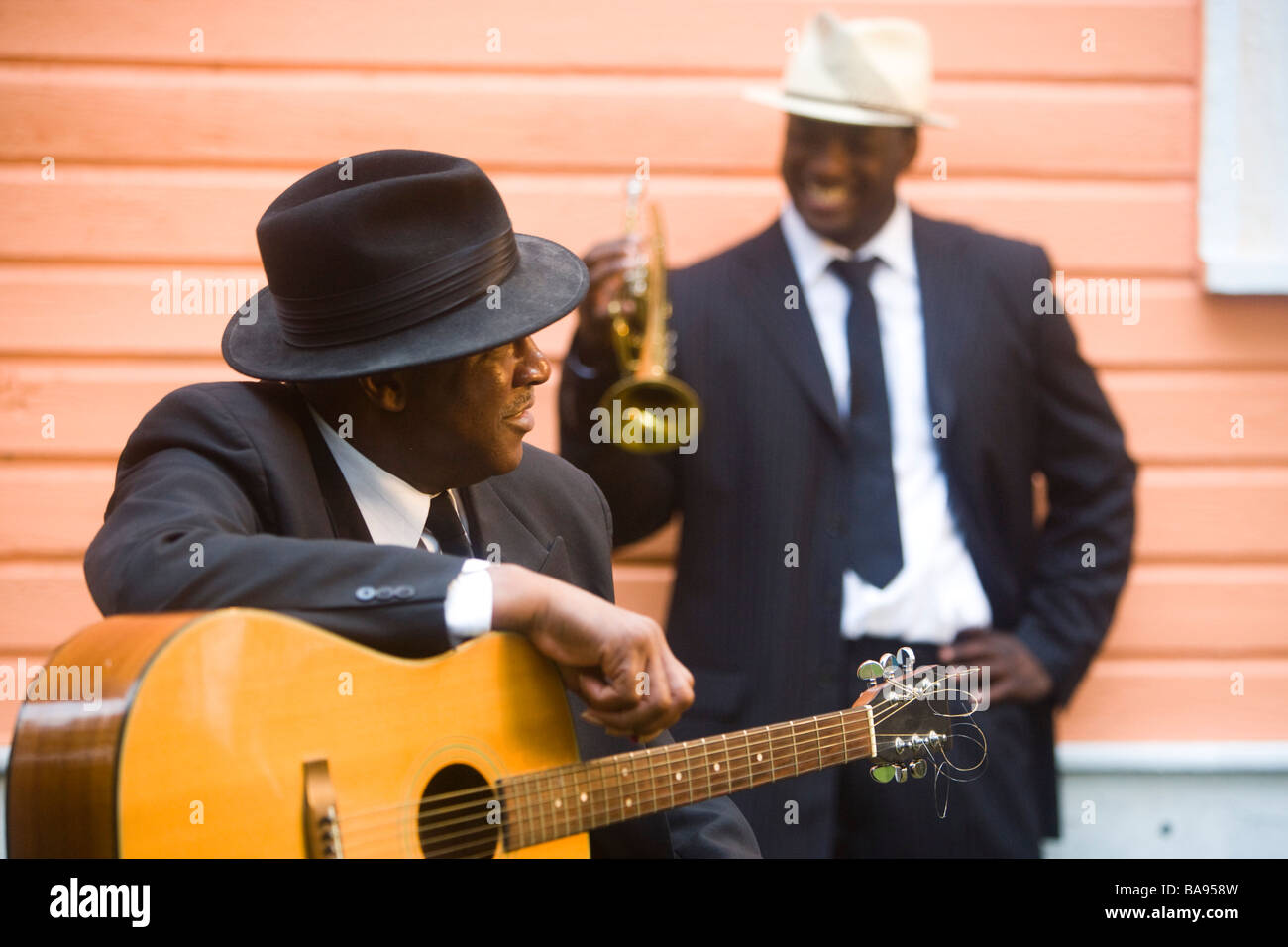 African American Blues musicians with guitar and trumpet outside house Stock Photo