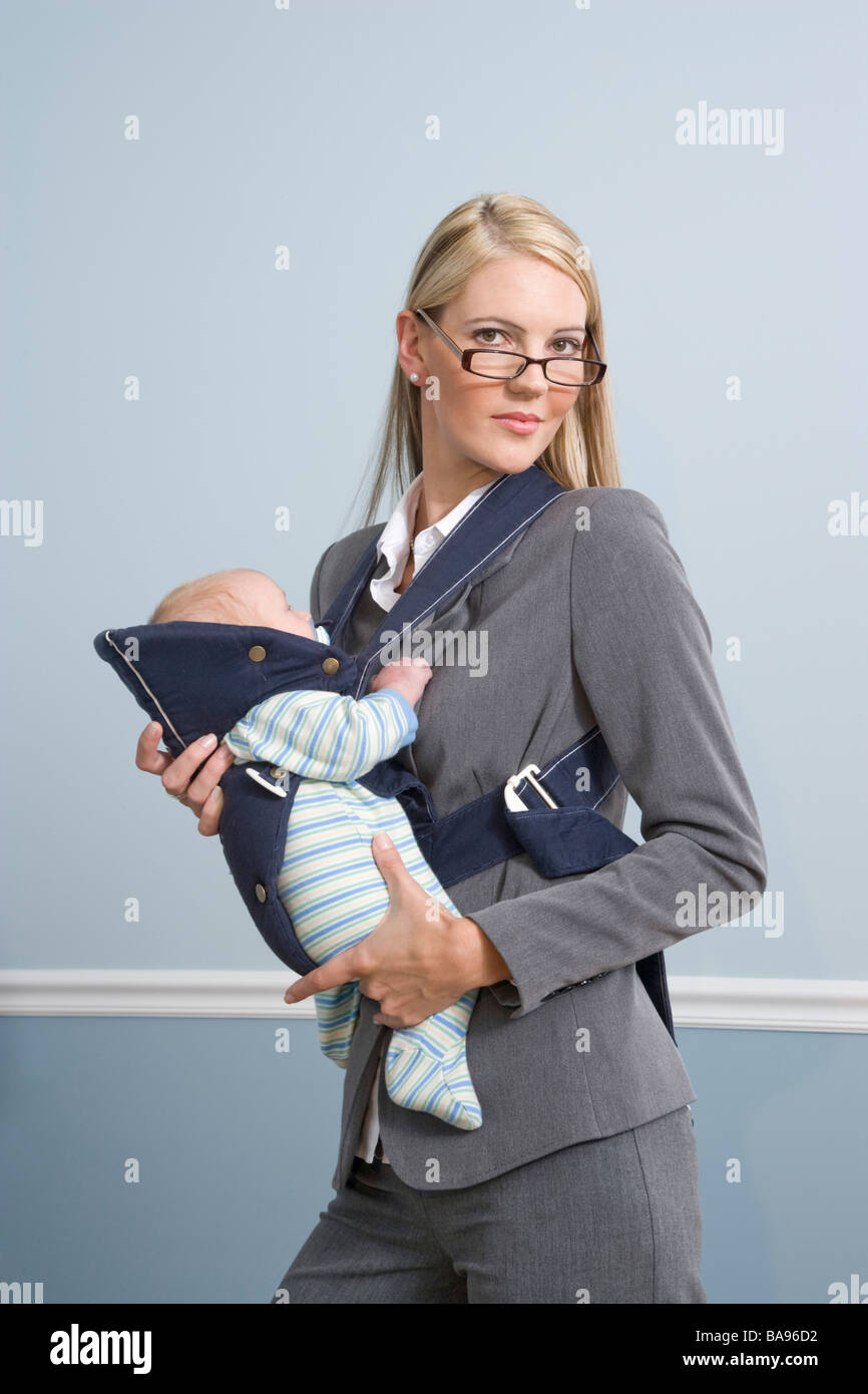 Young businesswoman holding baby at work Stock Photo