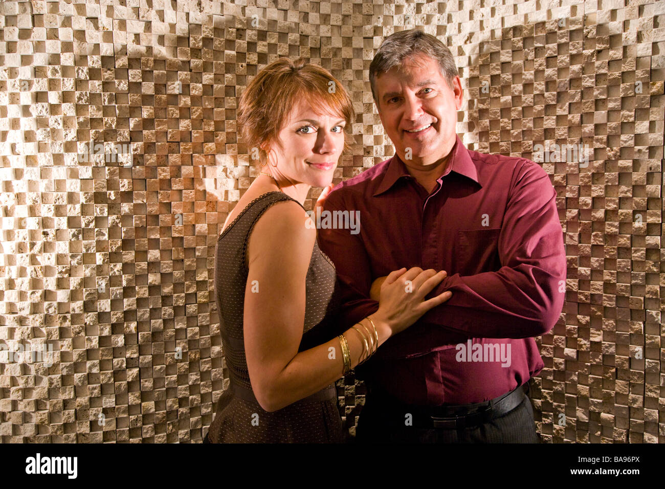 Portrait of smiling mature couple against textured wall Stock Photo - Alamy