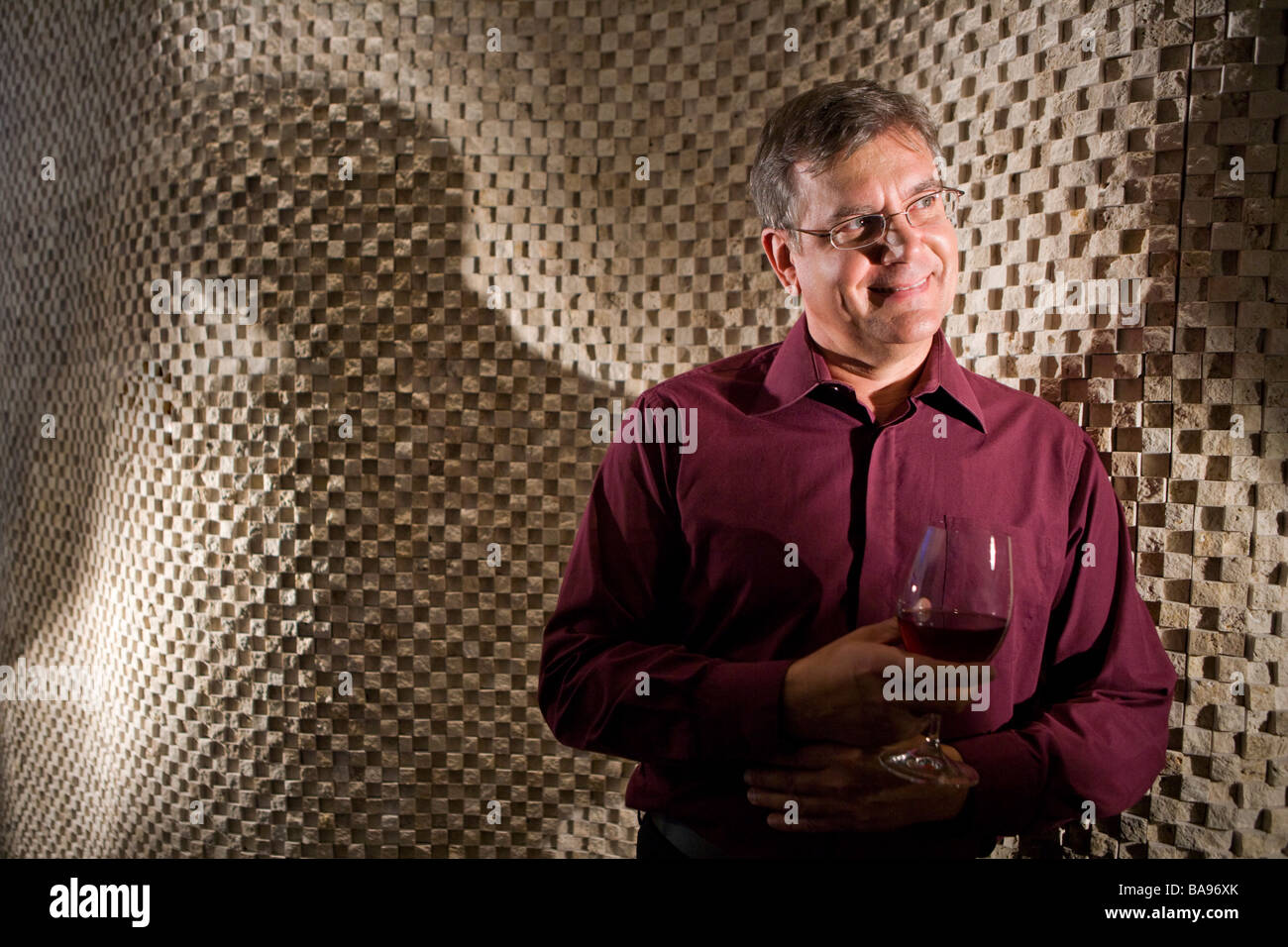 Mature man daydreaming while drinking glass of wine Stock Photo