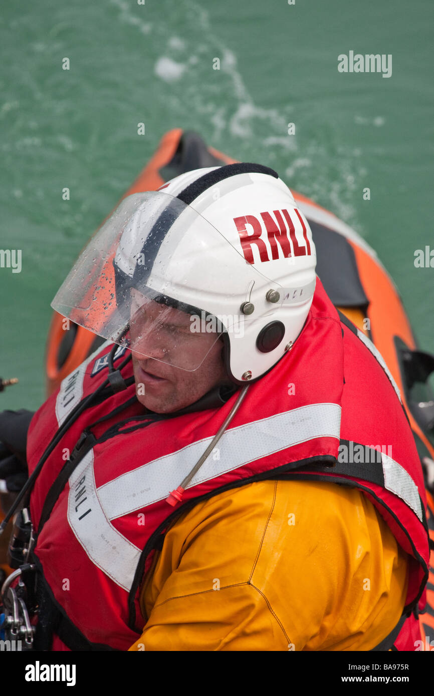 RNLI (Royal National Lifeboat Institution) crew member in a boat during a training exercise. Stock Photo