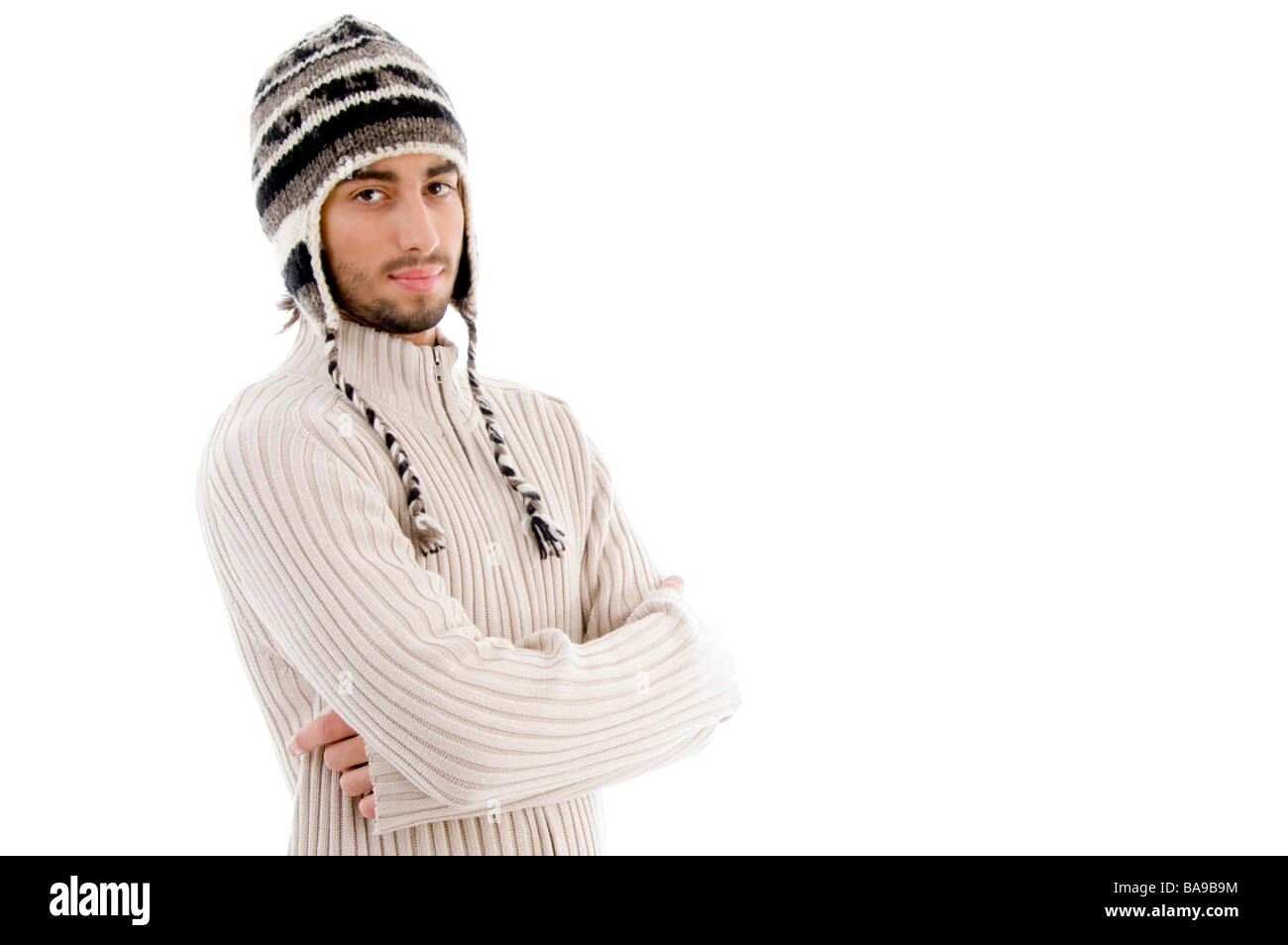handsome man wearing woolen cap and posing with crossed arms Stock