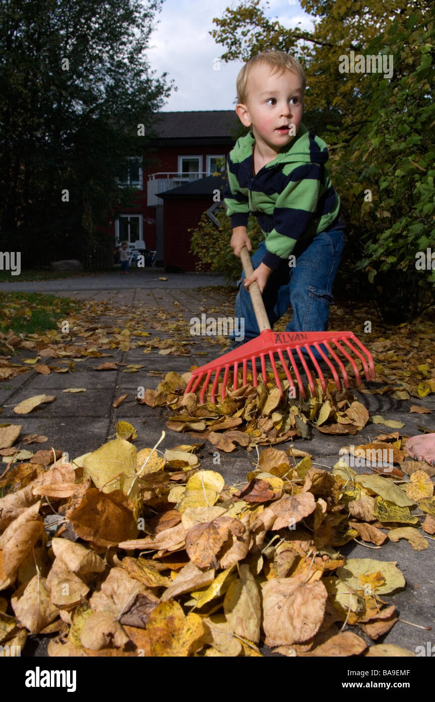 A child using a rake Ostergotland Sweden Stock Photo