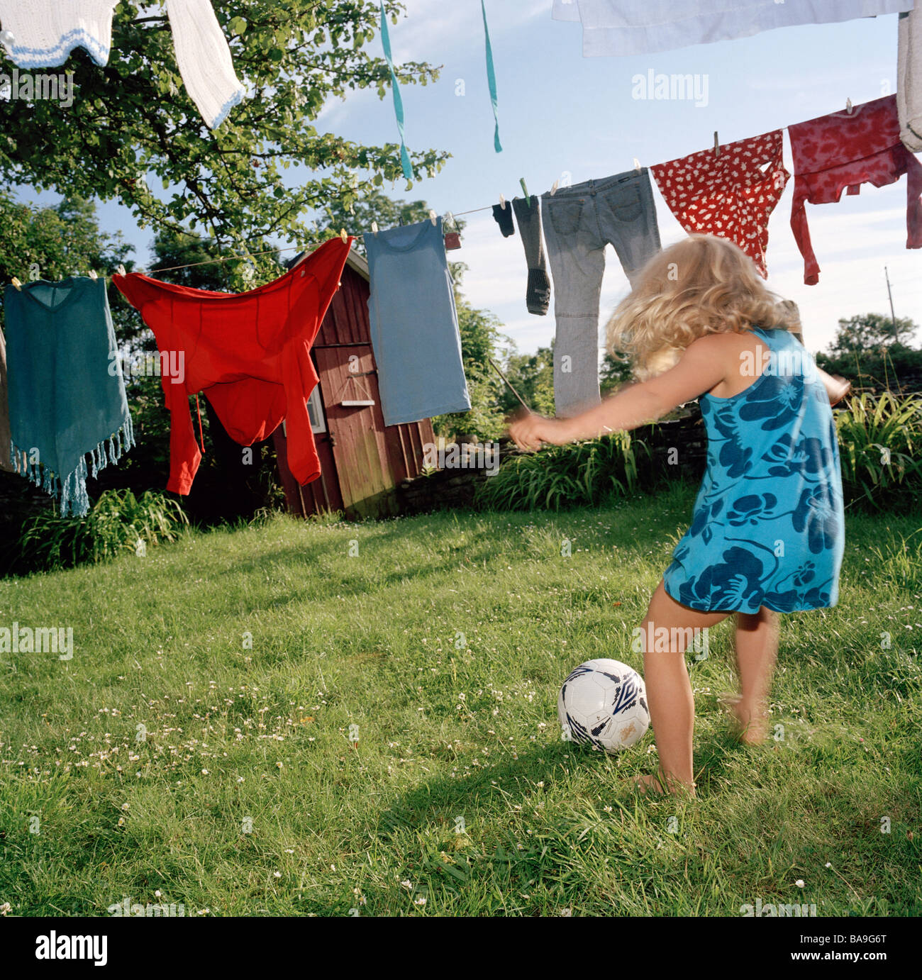 Girl playing soccer in the garden. Stock Photo