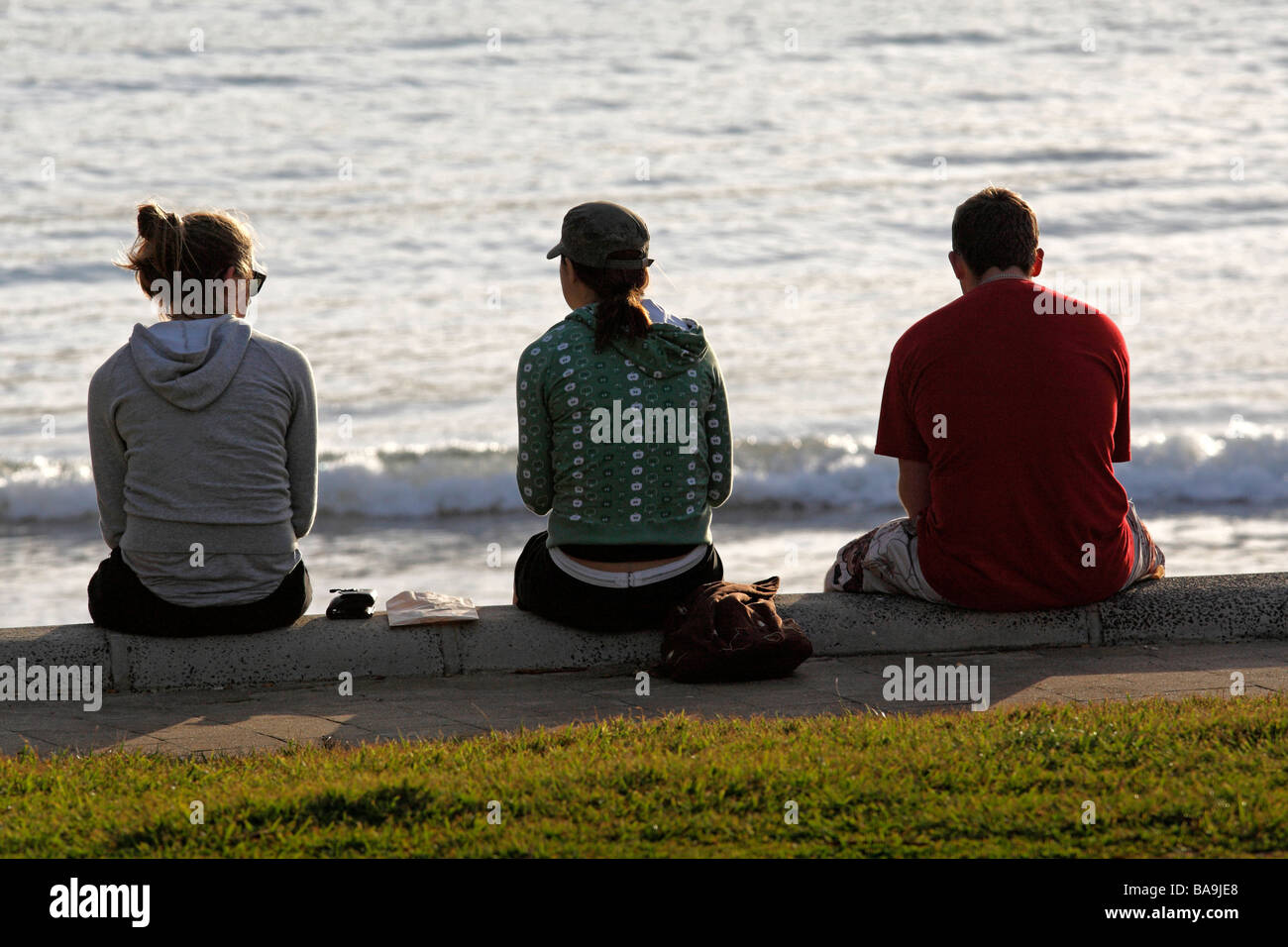 3 People Sitting on Foreshore Port Campbell Victoria Australia Stock Photo