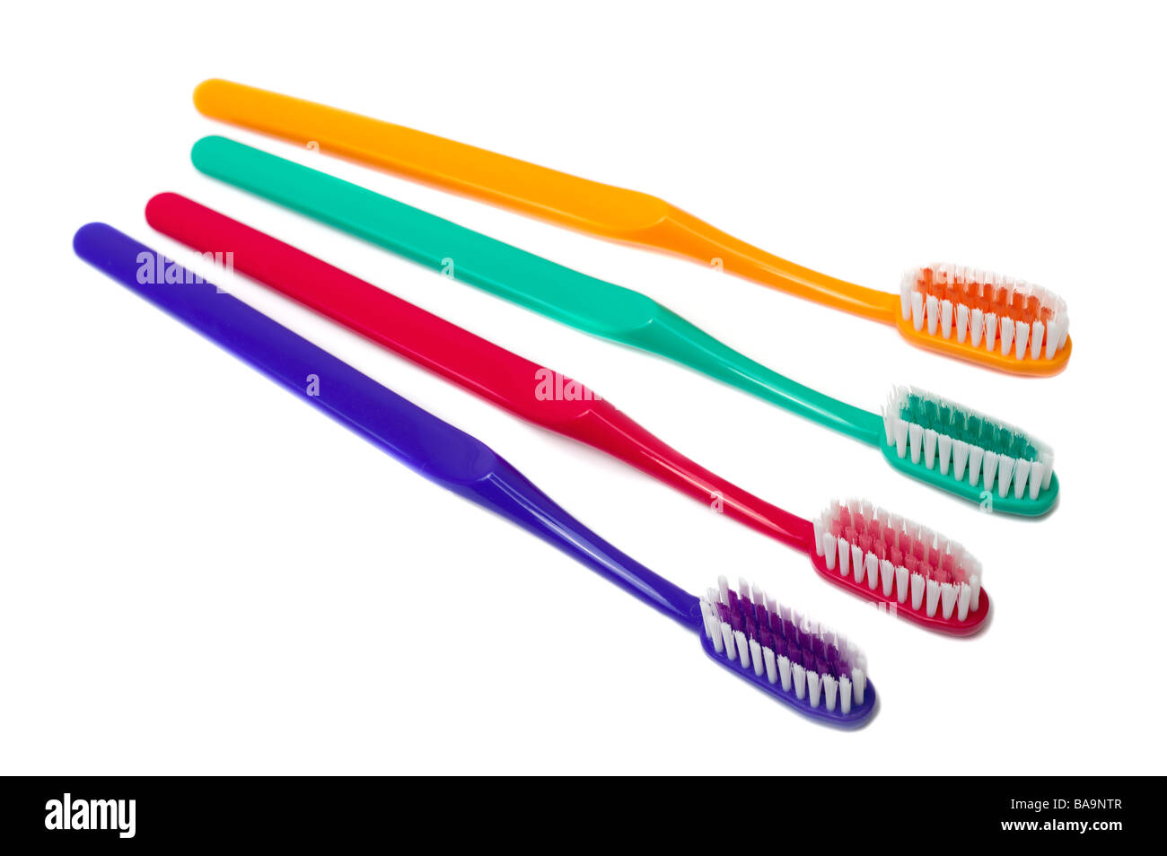 Four mixed coloured toothbrushes Stock Photo