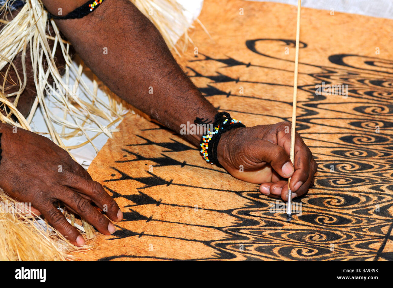 Bark painting, local artist paints traditional motifs on the bark of the Khambouw tree, Lake Sentani area, West Papua, Indonesia Stock Photo