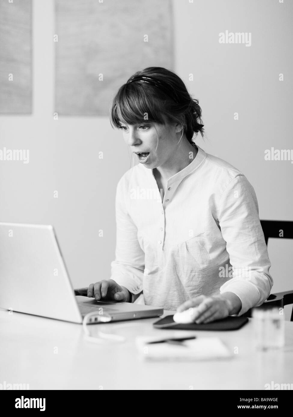 A surprised woman using a laptop, Sweden. Stock Photo