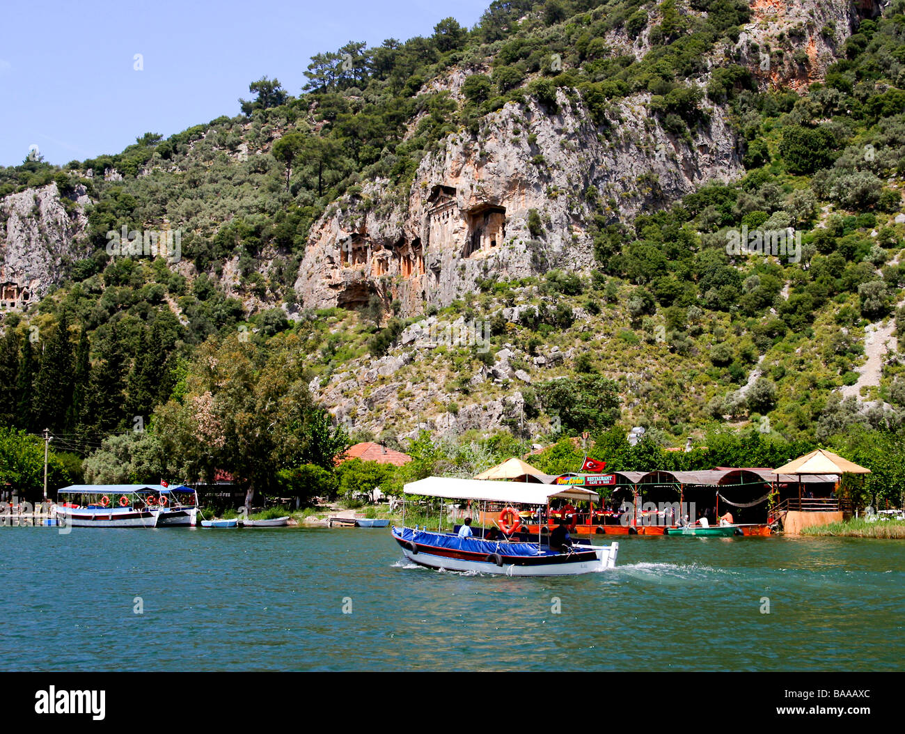 Tour boats on the river by the Ancient Rock Tombs at Kaunas, Dalyan, Turkey Stock Photo