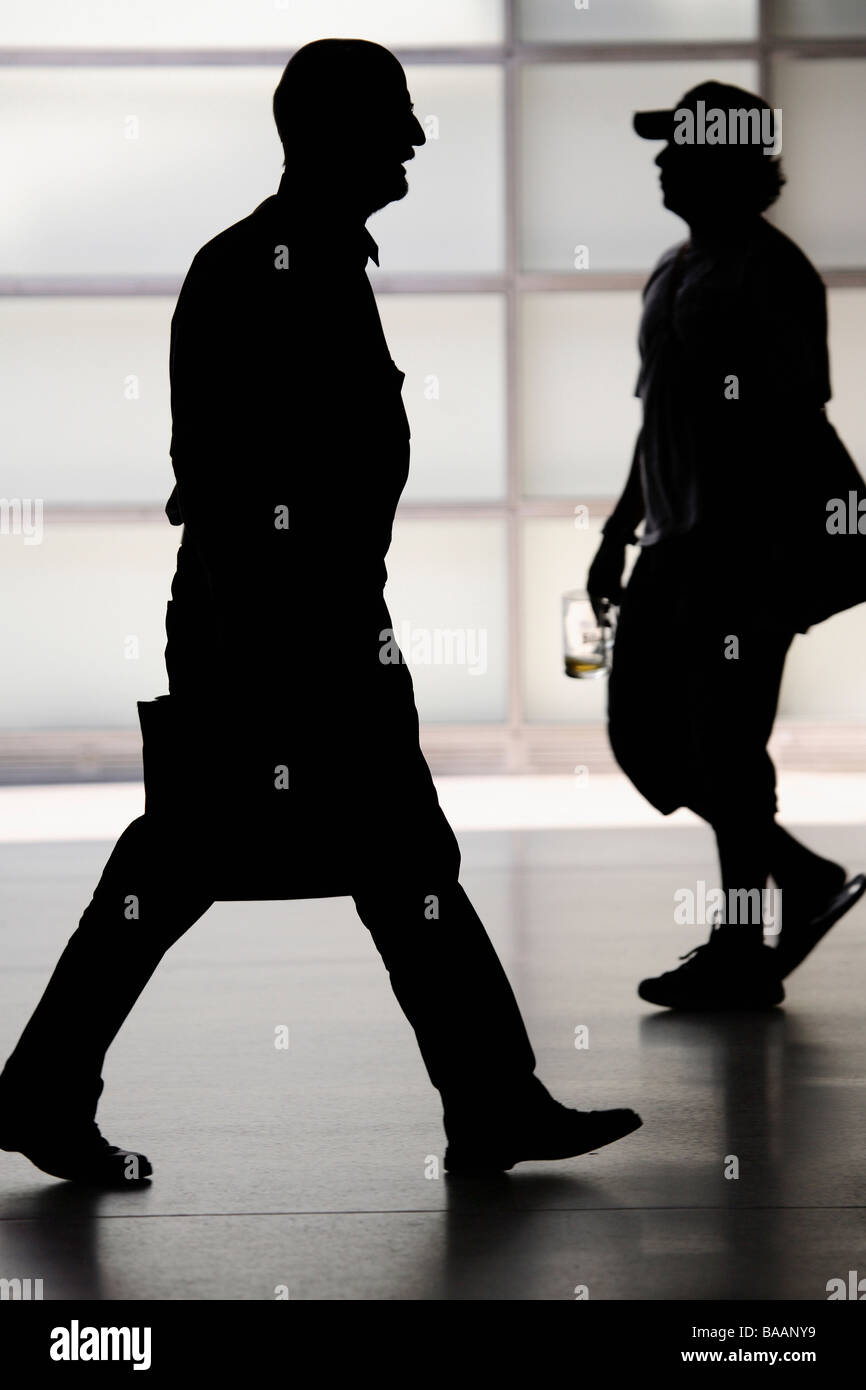 Silhouettes of two men, one with a briefcase and the other with a glass ...