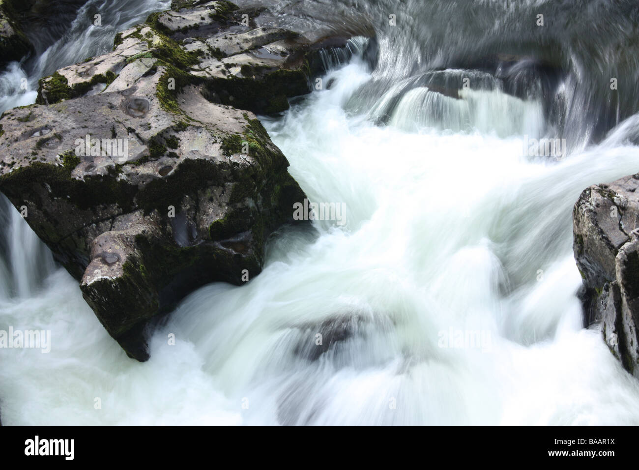 Moving milky water at Swallow Falls, Betws-Y-Coed, Snowdonia, Wales. Stock Photo
