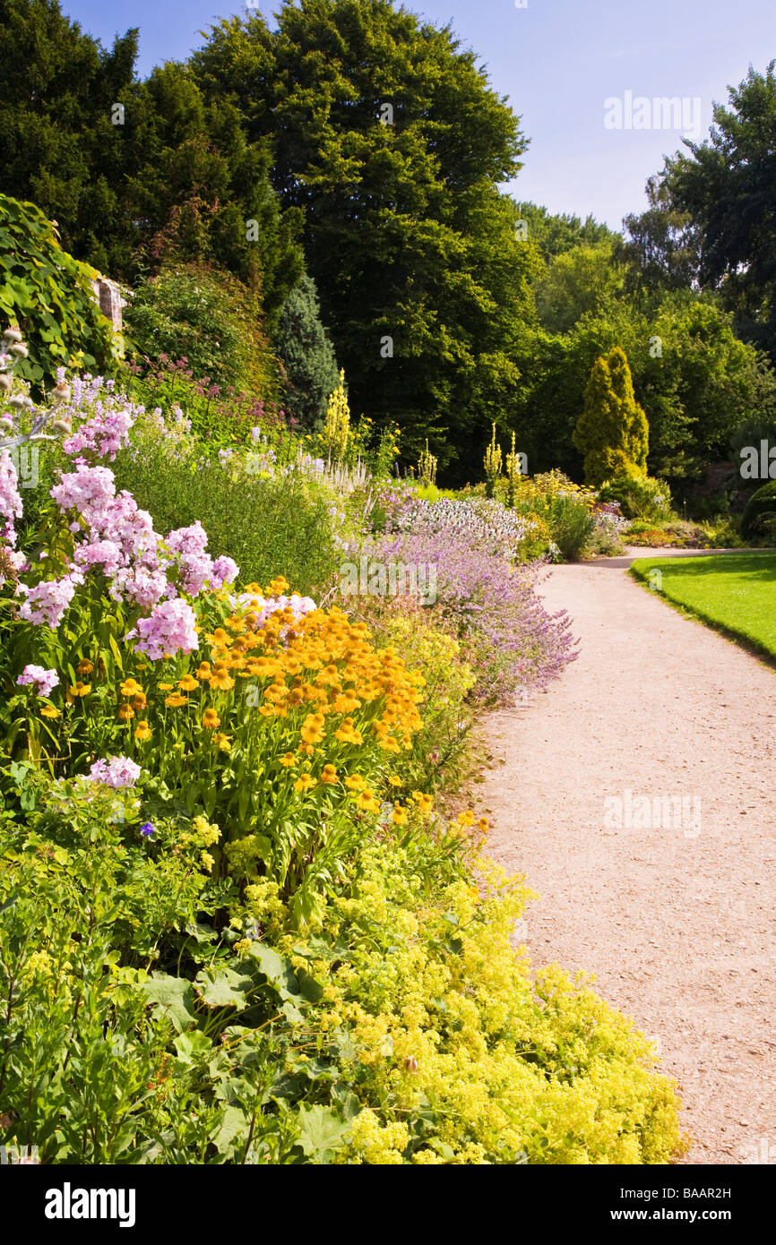 Herbaceous border at Waterperry Gardens Wheatley Oxfordshire with yellow Helenium and pink Phlox in the foreground Stock Photo