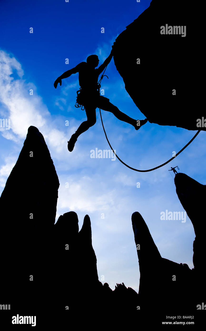 A rock climber clings to the side of an overhanging rock Stock Photo