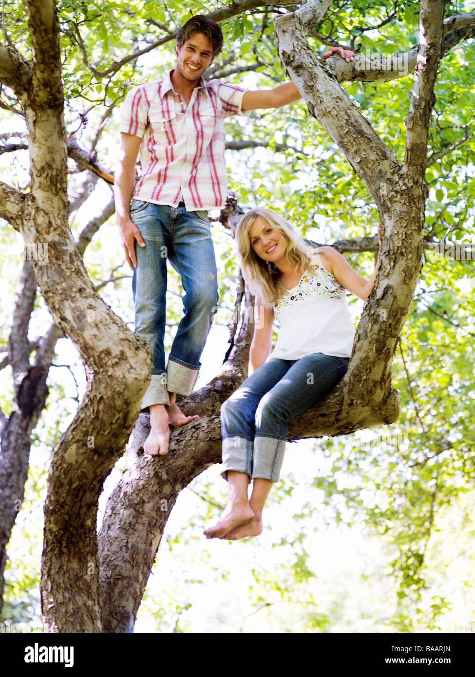 Couple sitting by tree hi-res stock photography and images - Alamy