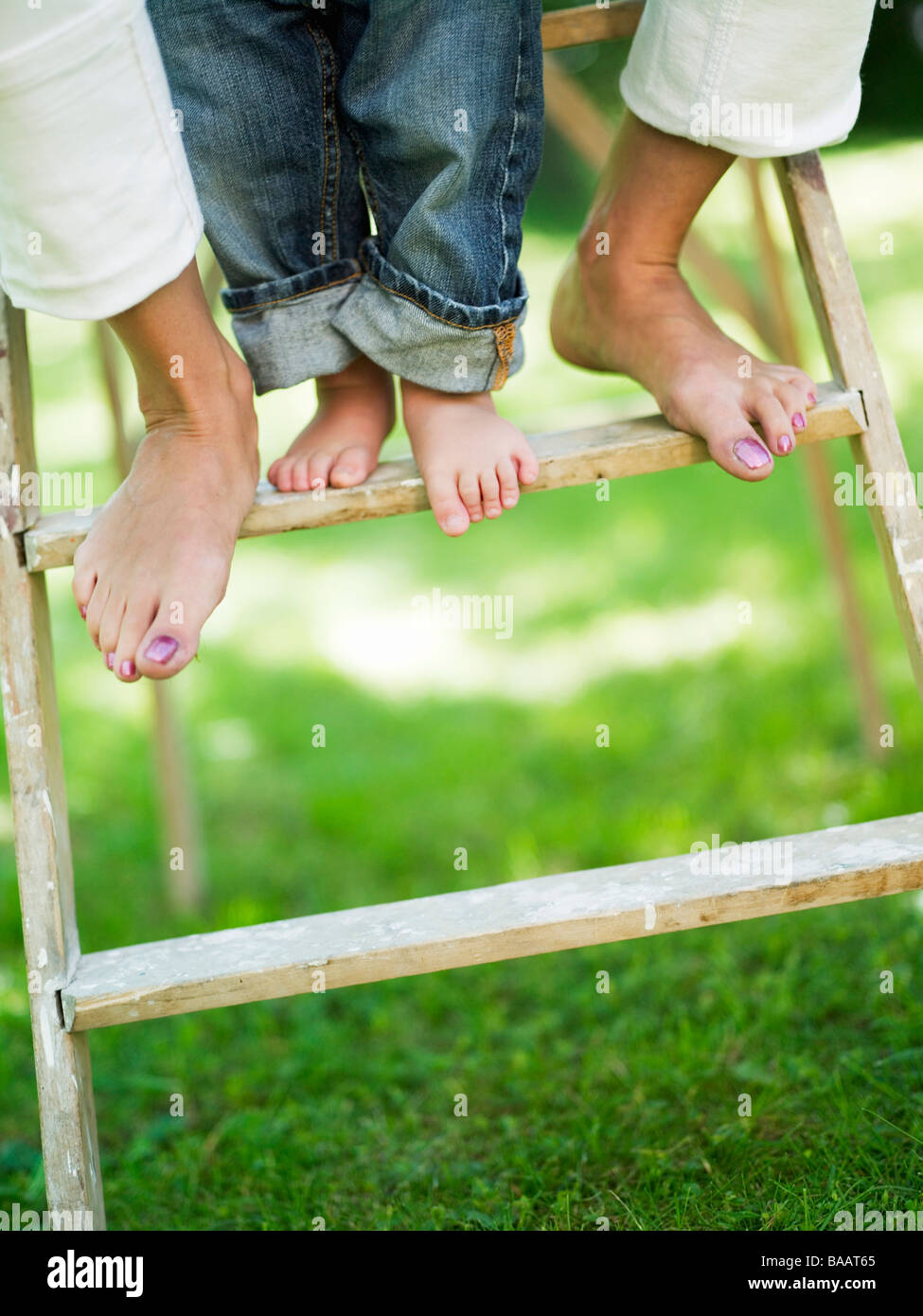 Two pair of legs on a ladder, Stockholm, Sweden. Stock Photo