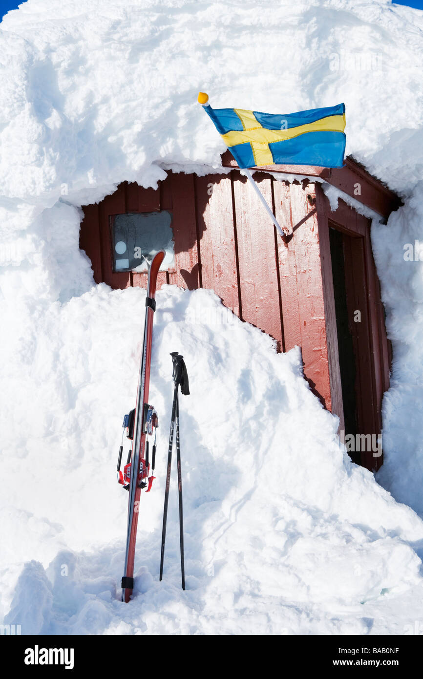 A Swedish flag on a cottage covered with snow, Sweden. Stock Photo