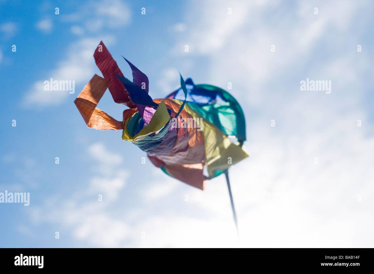 Multicoloured wind direction indicator against the sky flapping in the wind Stock Photo