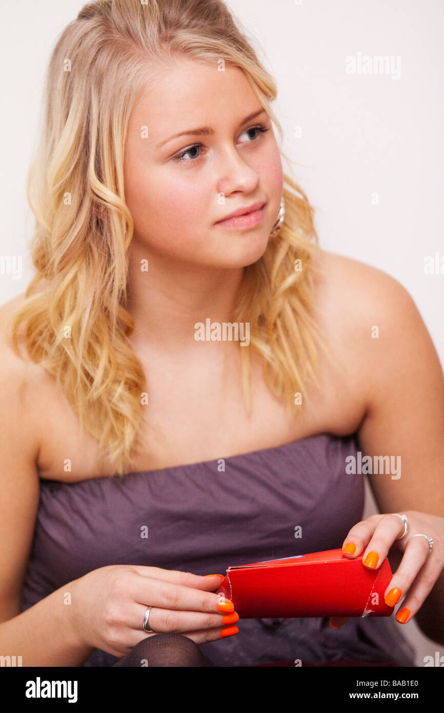 Teenager opening up a gift. Stock Photo