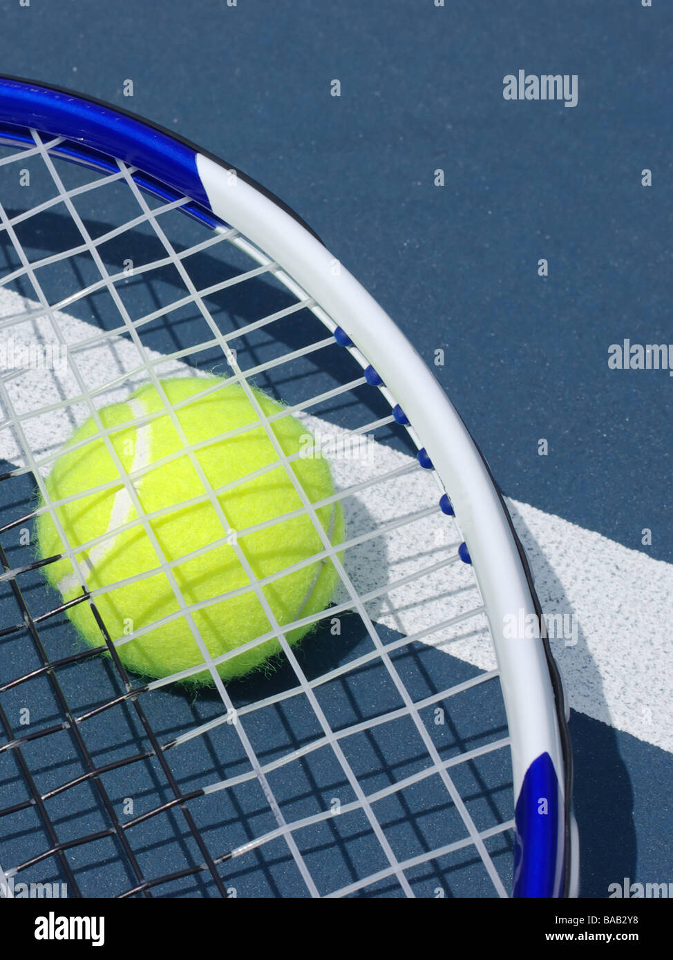 Tennis ball and racket over service line Stock Photo