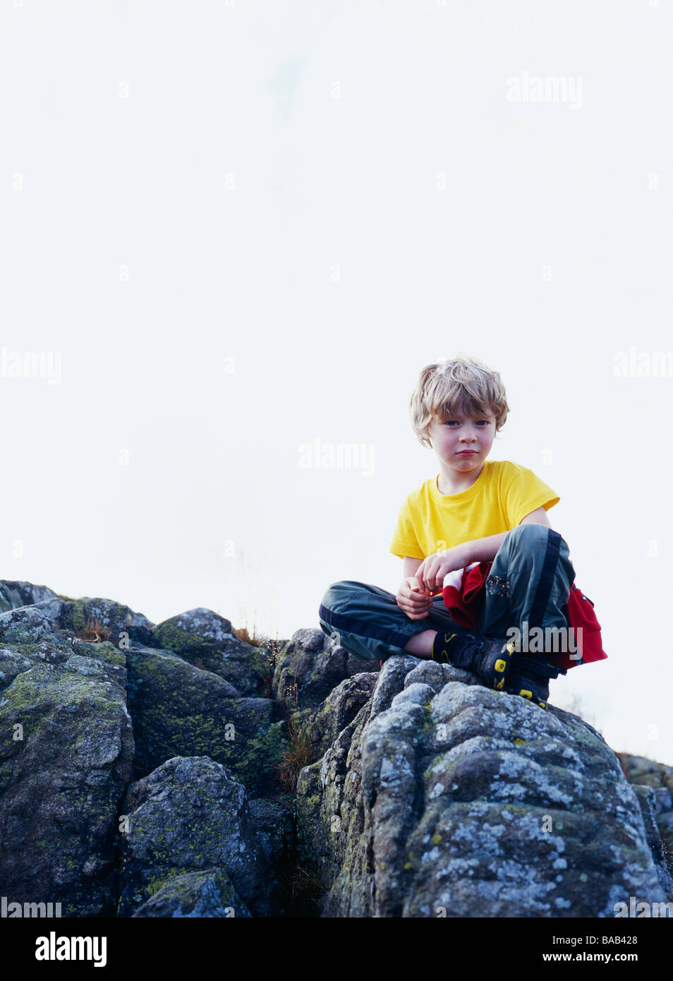 A Boy Sitting On A Mountain Stock Photo - Alamy