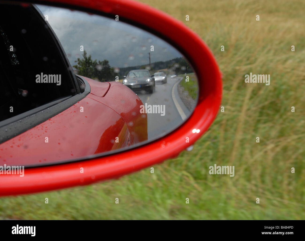 Porsche cars on a country road seen in a side mirror, Stuttgart, Germany Stock Photo