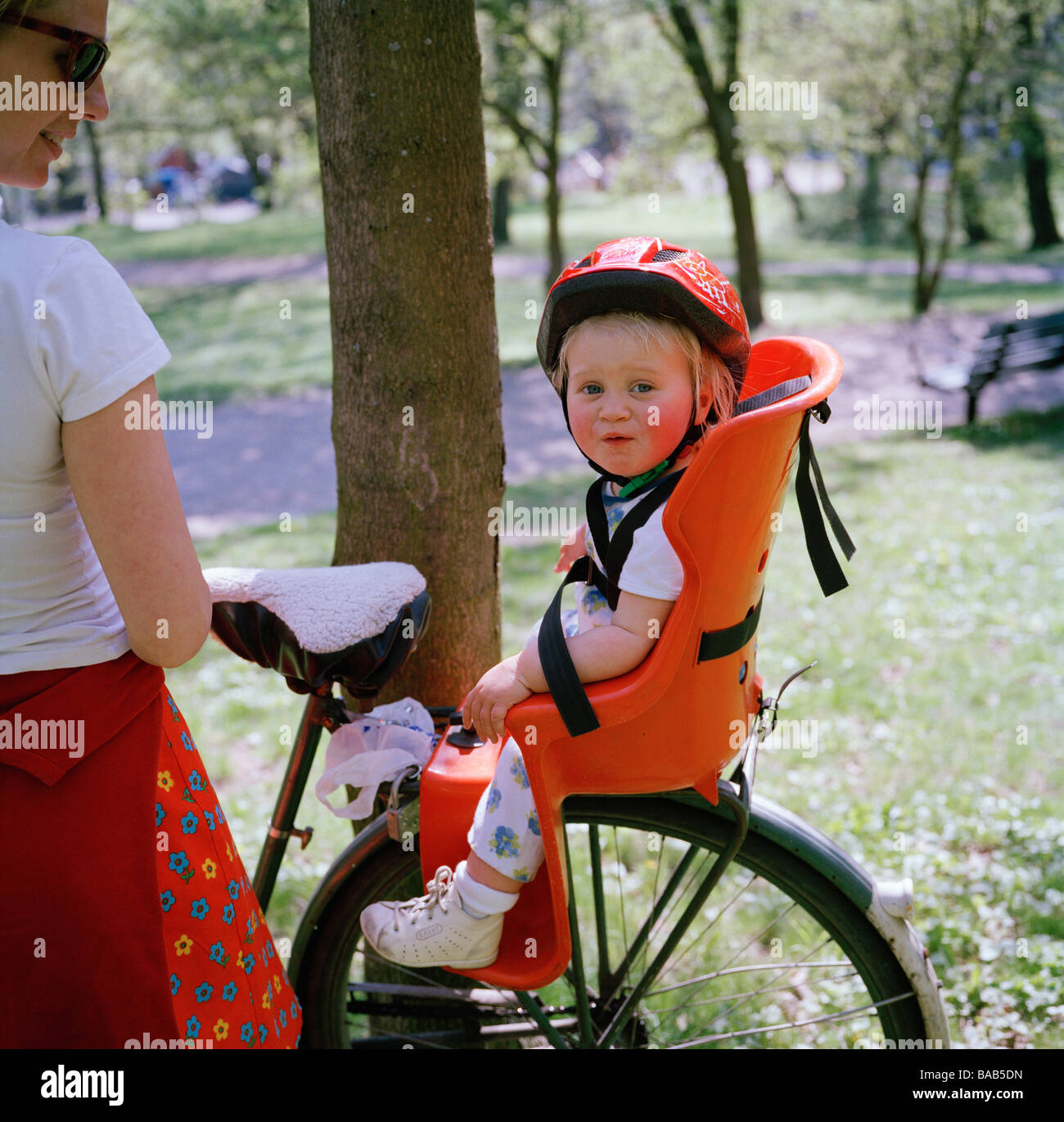 A Little Girl Sitting In A Child's Seat On A Bicycle Sweden. Stock Photo